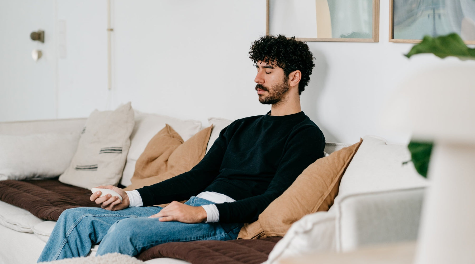Man using a moonbird for breathing exercises, with a dog beside him.